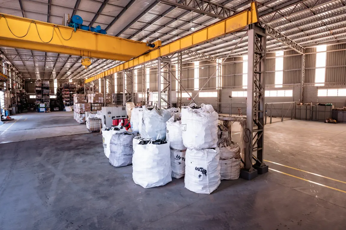 Galpão operacional com ponte rolante e big bags de materiais triados